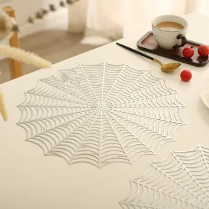 Detailed close-up of a hollow silver spider web placemat on a cozy table for Halloween decor.