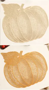 Exquisite hollow pumpkin placemat detail, Nordic style gold PVC table decor close up.