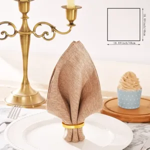 Detail shot of solid color cotton linen table napkin folded nicely with gold napkin ring.
