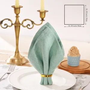 Elegant sage green cotton and linen napkin detailed view showcasing fine fabric texture and form.