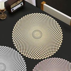 Gros plan détail du set de table PVC ajouré bronzant sur table noire, style nordique.