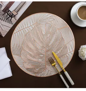 Detailed view of Nordic style round PVC monstera leaf gold stamped placemat, elegant dining table decor.