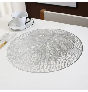 Detail view of the round Monstera leaf PVC placemat on dining table, Nordic heat-resistant style.