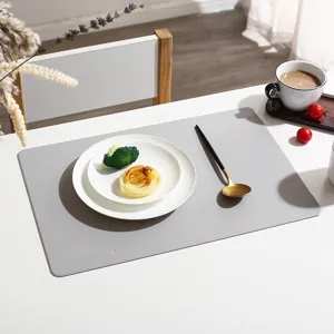 Close-up detail of a modern grey leather placemat displayed on a clean white dining table.