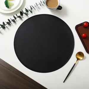 Close up of black round leather placemat detailed texture for modern table decor setting.