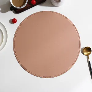 Detailed view of round leather placemat with exquisite edge stitching in stylish solid pink color.
