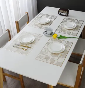 Elegant PVC gold-stamped placemat with ginkgo leaf pattern for dining table heat insulation.