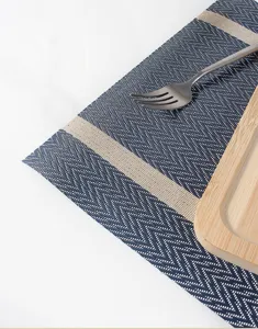 Primo piano di una tovaglietta tessuta a spina di pesce blu con strisce beige, dettaglio.