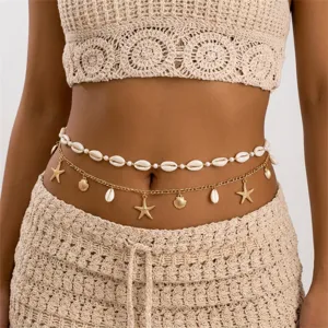 Detail view of a bohemian layered belly chain featuring cowrie shells and gold starfish charms.