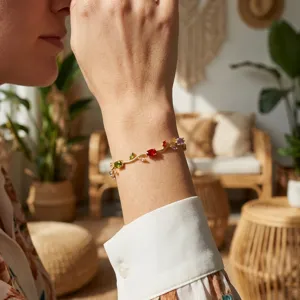 Lifestyle close-up of a gold vine bracelet with colorful flower petal gemstones on a wrist.
