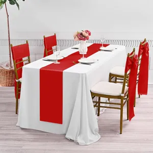 Elegante witte tafelkleed en rode tafelloper met bijpassende stoellussen voor feest.