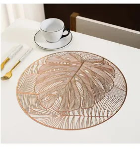 Detail view of a Nordic style round PVC hollow monstera leaf placemat with elegant gold finish.