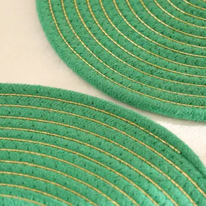 Close-up detail van groen gevlochten katoenen placemat met gouden draad textuur hittebestendig.