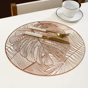 Round PVC placemat with gold stamped monstera leaf pattern, elegant dining table decor.