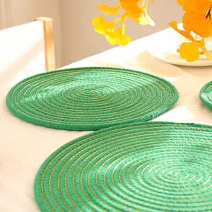 Gedetailleerd overzicht van groen geweven katoenen placemat met goudkleurig spiraleffect, hitte.