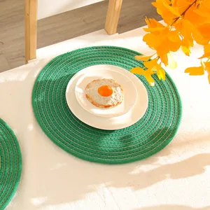 Detailweergave van groene ronde katoenen placemat met goudraad, warmte-isolerende tafelmat.
