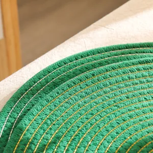Close-up detail van groene gevlochten katoenen placemat met glinsterende metalen draden.