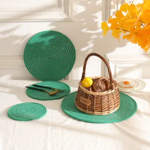 Detailopname van groene geweven katoenen placemats en pannenlappen in een rustieke mand.
