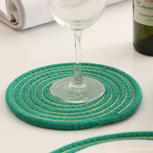 Close-up van de groene gewoven placemat details met gouden draad voor een sfeervolle tafel.