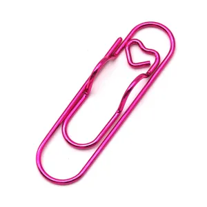 Detail view of a hot pink metal paper clip with heart shape, perfect for notebook pen holder.