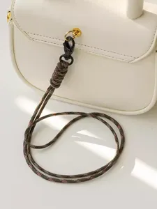 Detailed shot of a stylish braided lanyard attached to a white handbag, premium craftsmanship.
