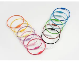 Colorful stainless steel wire keychains in a V-shaped arrangement, detailed close-up shot.