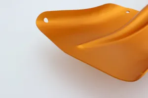 Aluminum alloy snow shovel detail view, vibrant orange metallic finish with mounting holes.