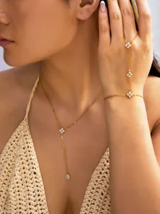 Détail du collier en Y doré et de la chaîne de main assortie avec motifs fleurs zircon