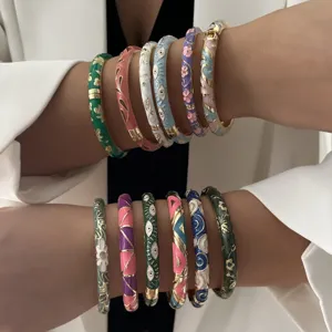 Detailed view of ethnic style enamel bangles with colorful floral and eye patterns