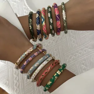 Detailed view of ethnic enamel bangles featuring floral and evil eye patterns