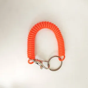 Detailed close-up of vibrant orange coiled spring keychain, stretchy wrist lanyard with metal clasp.
