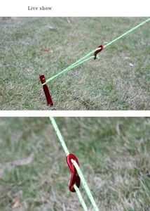 Outdoor aluminum alloy tent rope buckle detail, red guyline adjuster in grass setup.