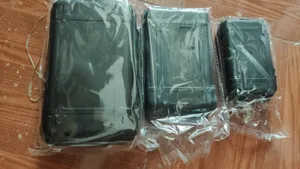 Detailed view of three sizes of black outdoor waterproof survival plastic storage cases securely wrapped.