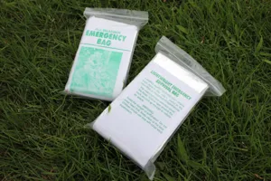 Detail view of PE aluminum emergency survival sleeping bags in waterproof transparent package.