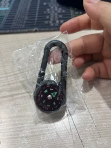 Outdoor portable metal compass with carabiner, durable alloy pocket navigation tool for camping.