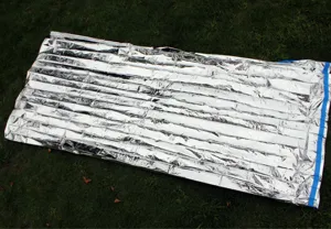 Detail shot of PE silver emergency survival thermal blanket outdoor waterproof camping gear.