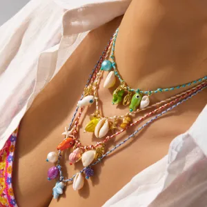 Detail of layered Bohemian beach necklaces with colorful shell and starfish charms