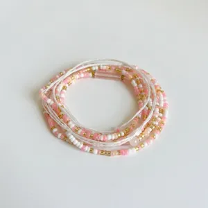 Detailed view of bohemian multi-layered pink white and gold seed bead beach waist chain