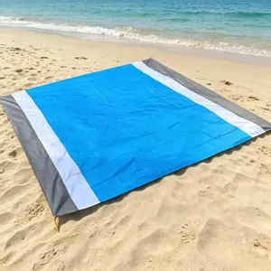 Detailed view of waterproof beach picnic mat, blue and white striped outdoor camping ground sheet.