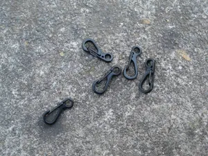 Nahaufnahme schwarzer Mini-Federhaken, kleine Metall-Karabinerklips für EDC-Schlüsselanhänger.