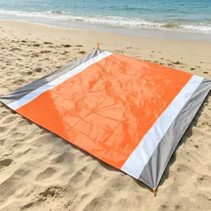 Waterproof beach mat detail shot, showing orange grey striped portable picnic camping blanket.