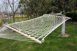 Detail van outdoor katoenen touw hangmat met stevige witte geweven structuur en houten stangen.
