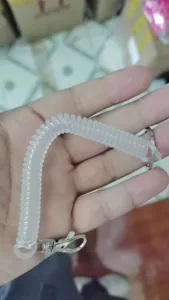 Close up view of the clear elastic coiled spring keychain lanyard with sturdy metal clasp and ring.