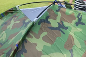 Camouflage camping tent top detail showing waterproof fabric and durable support poles for outdoor.