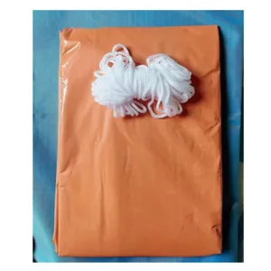 Détail de tente d'urgence de survie avec sac orange plié et corde en nylon blanche.
