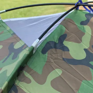 Camouflage camping tent top close-up, featuring waterproof fabric and sturdy poles.