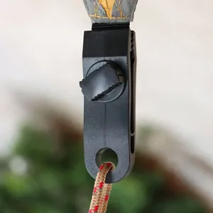 Vue détaillée de la pince de tente en plastique noir avec vis réglable pour usage extérieur.