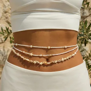 Detailed close-up view of bohemian beach waist chain with starfish, shells and pearls.