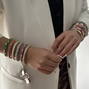 Close-up of vibrant ethnic enamel floral pattern bangles stacked on a model's arm
