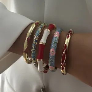 Close-up of colorful ethnic enamel bangles with floral patterns and bamboo designs.